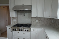 Custom-designed tile backsplash in kitchen